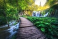 Waterfall and wooden path in green forest in Plitvice Lakes Royalty Free Stock Photo