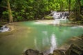 Waterfalls and fish swim in the emerald blue water in Erawan National Park. Erawan Waterfall is a beautiful natural rock waterfall Royalty Free Stock Photo