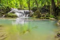 Waterfalls and fish swim in the emerald blue water in Erawan National Park. Erawan Waterfall is a beautiful natural rock waterfall Royalty Free Stock Photo