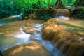 Waterfalls and fish swim in the emerald blue water in Erawan National Park. Erawan Waterfall is a beautiful natural rock waterfall Royalty Free Stock Photo