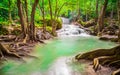 Waterfalls and fish swim in the emerald blue water in Erawan National Park. Erawan Waterfall is a beautiful natural rock waterfall Royalty Free Stock Photo