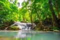 Waterfalls and fish swim in the emerald blue water in Erawan National Park. Erawan Waterfall is a beautiful natural rock waterfall Royalty Free Stock Photo