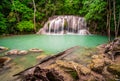 Waterfalls and fish swim in the emerald blue water in Erawan National Park. Erawan Waterfall is a beautiful natural rock waterfall Royalty Free Stock Photo