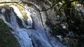 Waterfalls on mountain river slow motion view, clearness and freshness of nature. Winter sunny day.