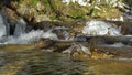 Waterfalls on mountain river slow motion view, clearness and freshness of nature. Winter sunny day.