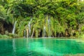 Waterfalls over the Turquoise Waters of the Lake. Natural Environment with Emerald Water, Green Trees and a Deep Forest in Croatia Royalty Free Stock Photo