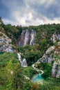 Waterfalls reflected in the lake. The magnificent landscape of the waterfall and lake. Majestic view of the Plitvice