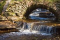 Waterfalls in the stream with an old arch bridge Royalty Free Stock Photo