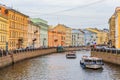 Waterfront buildings on the banks of river Neva and tourist boats on the water in Saint Petersburg