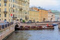 Waterfront buildings on the banks of river Neva and tourist boats on the water in Saint Petersburg