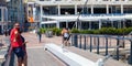 Family, couples and a man wearing face masks. Walking over the bridge crossing at the Waterfront. Royalty Free Stock Photo