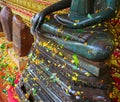 Watering Buddha statues with scented water and flower petals during Lao New Year