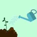 Watering can sprays water drops. New plant, sprout, sapling with heap of ground. Royalty Free Stock Photo