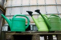 Watering cans at farm water tank Royalty Free Stock Photo