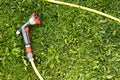 Watering garden hose nozzle on a green grass Royalty Free Stock Photo