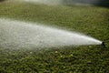 Watering grass. Sprinklers watering grass, green lawn in garden. Automatic sprinkler irrigation system working in a Royalty Free Stock Photo