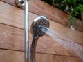 Waterjets flowing out of handheld shower head in outdoor shower Royalty Free Stock Photo