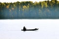 Waterman. Old Veps moves across lake in makeshift wooden boat Royalty Free Stock Photo