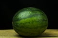 Watermelon big drop on wood, on a black background Royalty Free Stock Photo