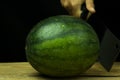 Watermelon big drop on wood, on a black background Royalty Free Stock Photo