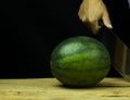 Watermelon big drop on wood, on a black background Royalty Free Stock Photo