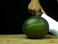 Watermelon big drop on wood, on a black background Royalty Free Stock Photo