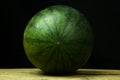 Watermelon big drop on wood, on a black background Royalty Free Stock Photo