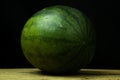 Watermelon big drop on wood, on a black background Royalty Free Stock Photo