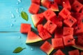 Watermelon chunks displayed on a blue wooden surface, offering copyspace