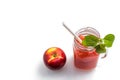 Watermelon cocktail in a jar with mint leaves, Apple on a saucer and a cocktail straw on a white background. Royalty Free Stock Photo