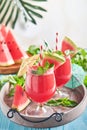 Watermelon cocktail with mint and ice. Summer refreshing drinks in glasses on blue wooden table. Concept of healthy summer eating Royalty Free Stock Photo