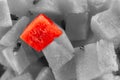 Watermelon cube highlighted against a background of fruit in gray tones, one of all the bright