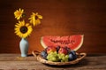 Watermelon, fruit and sunflowers in a vase Royalty Free Stock Photo