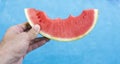 Watermelon in the hand of a girl in swimming pool Royalty Free Stock Photo