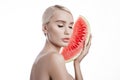 Watermelon in hands of women, clean smooth skin of body and face. Blonde girl in summer holding a watermelon in hands of face. Royalty Free Stock Photo