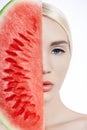 Watermelon in hands of women, clean smooth skin of body and face. Blonde girl in summer holding a watermelon in hands of face. Royalty Free Stock Photo