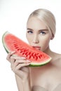 Watermelon in hands of women, clean smooth skin of body and face. Blonde girl in summer holding a watermelon in hands of face. Royalty Free Stock Photo