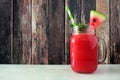 Watermelon juice in a mason jar, side view against dark wood Royalty Free Stock Photo