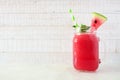 Watermelon juice in a mason jar, side view against white wood Royalty Free Stock Photo