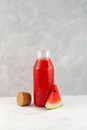 Watermelon juice or smoothie in glass bottle. Refreshing drink with fresh watermelon juice. Agua fresca cocktail. Grey background Royalty Free Stock Photo
