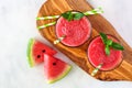 Watermelon juice on a wood serving board, overhead view on marble