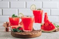 Watermelon lemonade with lime and fresh basil leaves on concrete background. Refreshing summer drink Royalty Free Stock Photo