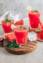 Watermelon lemonade with lime and fresh basil leaves on concrete background. Refreshing summer drink Royalty Free Stock Photo