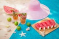 Watermelon mojito cocktail on wooden table. Watermelon, limes, starfishes, seashells and hat near. Selective focus Royalty Free Stock Photo