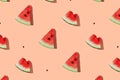 Watermelon pattern made of sliced watermelon on coral pink background.