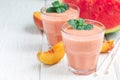 Watermelon, peach, mint and coconut milk smoothie in glass on white wooden background, horizontal, copy space Royalty Free Stock Photo