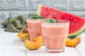 Watermelon, peach, mint and coconut milk smoothie in glass on white wooden background, horizontal, copy space Royalty Free Stock Photo