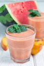 Watermelon, peach, mint and coconut milk smoothie in glass on white wooden background, vertical Royalty Free Stock Photo