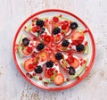 Watermelon pizza, vegetarian, fruit pizza with creamy natural yogurt and fresh fruits on a plate, on a white wooden table, top v