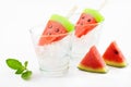 Watermelon popsicles homemade on ice glass and mint white background